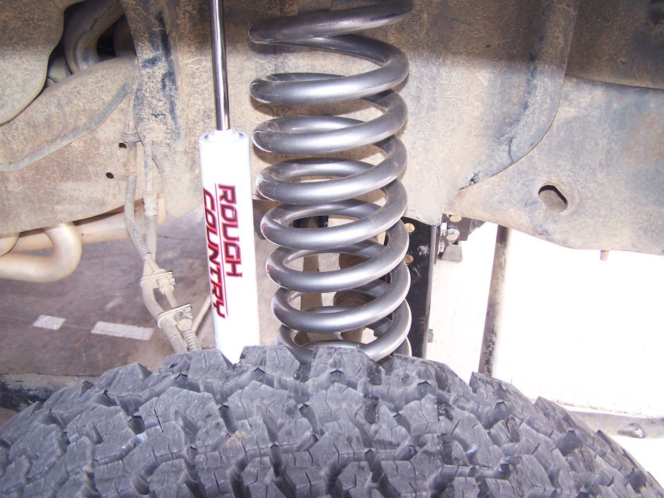 Coil spring and Rough Country shock absorber on off-road tire
