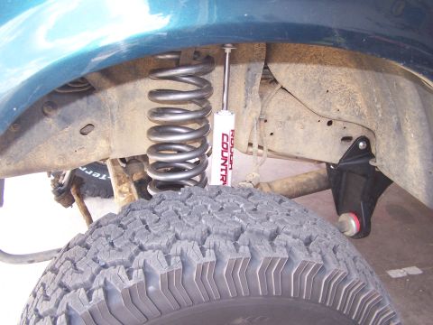 1995 Ford Bronco - The image shows a close-up of a vehicle's suspension system, including a coil spring and a shock absorber.