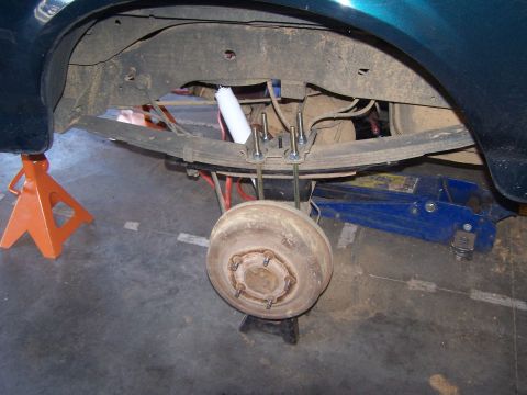 1995 Ford Bronco - Close-up view of a vehicle's rear suspension and axle components, indicating modifications or undergoing modification.