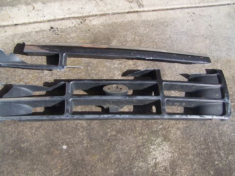 1995 Ford Bronco - This is a grille assembly for a 1995 Ford Bronco, a chrome trim piece and the central emblem mount.