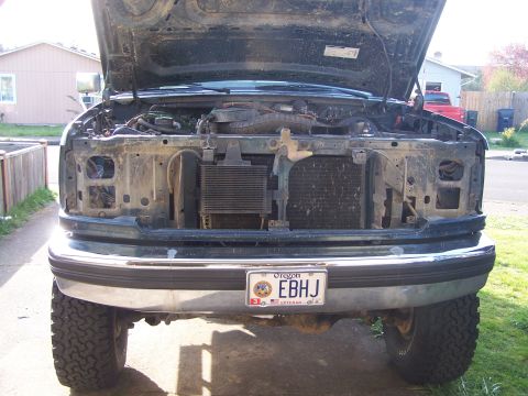 1995 Ford Bronco - Front view of a 1995 Ford Bronco with the hood open, revealing the engine and radiator assembly.