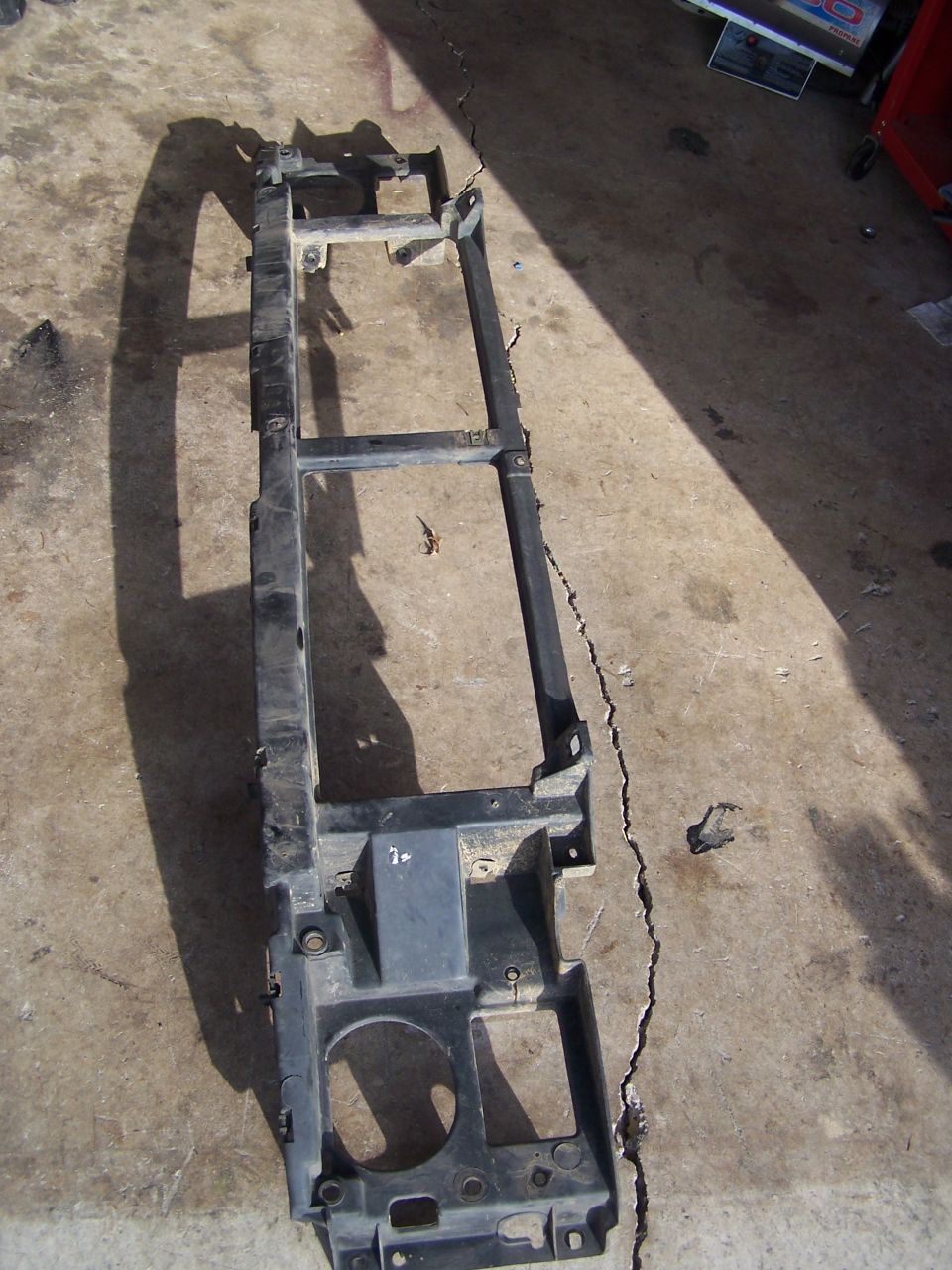 Black plastic and metal radiator support frame, likely from a truck or SUV