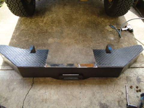 1995 Ford Bronco - Custom steel bumper with winch mount and diamond plate accents. Tools and parts are scattered around.