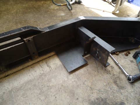 1995 Ford Bronco - A close-up view of a black metal bumper part, possibly for a truck or SUV, resting on a concrete surface.