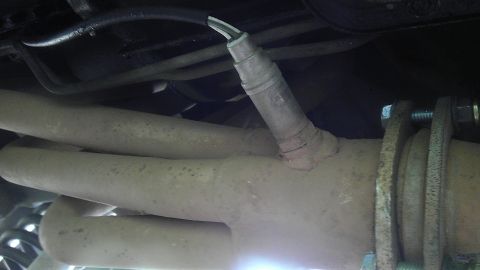 1995 Ford Bronco - Close-up view of an exhaust pipe and oxygen sensor.