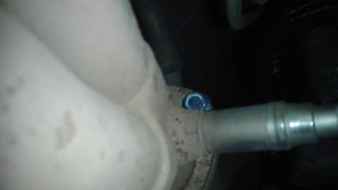 1995 Ford Bronco - Close-up of an exhaust pipe with a sensor, showing part of the vehicle's undercarriage.