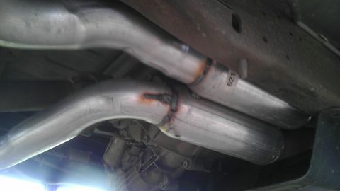 1995 Ford Bronco - Dual exhaust pipes are welded together under the vehicle's frame.