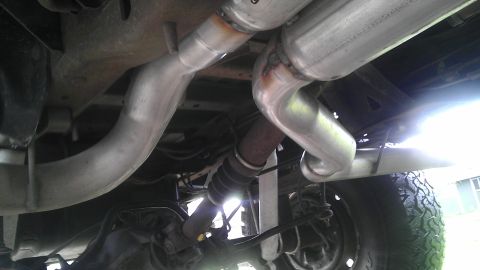 1995 Ford Bronco - The undercarriage of a vehicle displays its exhaust system components, including mufflers and pipes.