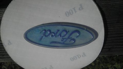 1995 Ford Bronco - A close-up of a Ford emblem is shown on a piece of sandpaper, with text indicating grit levels.