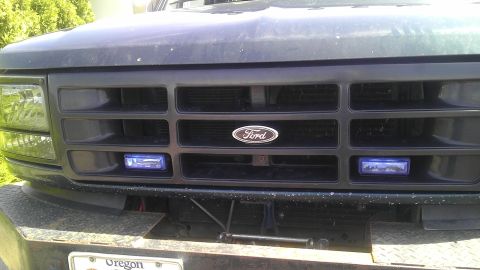 1995 Ford Bronco - Front view of a 1995 Ford Bronco grille, the Ford emblem and blue lights.