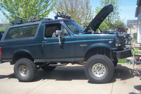 1995 Ford Bronco - This 1995 Ford Bronco features a lifted suspension, roof rack, and auxiliary lighting, suggesting off-road modifications.