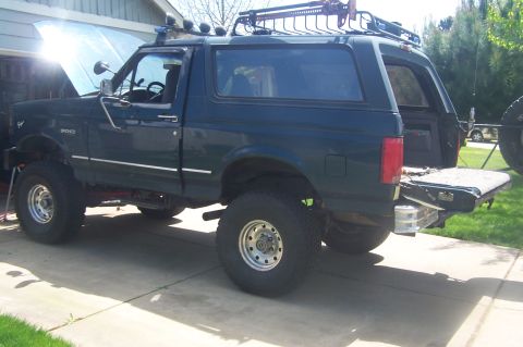 1995 Ford Bronco - This SUV has a roof rack and is parked in a driveway with the hood up.