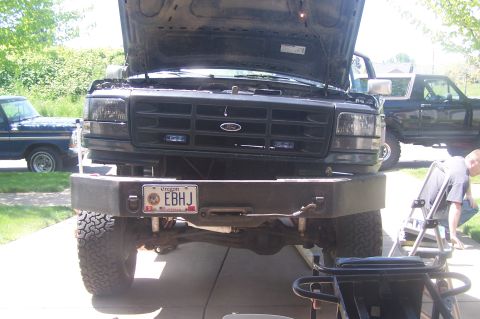 1995 Ford Bronco - Front view of a 1995 Ford Bronco with its hood open, parked next to another Ford truck.