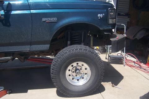 1995 Ford Bronco - This Ford Bronco is undergoing modifications, with its suspension lifted and a large off-road tire mounted.
