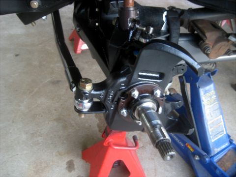 1996 Ford Bronco - Vehicle steering knuckle and suspension parts are visible, supported by jack stands.