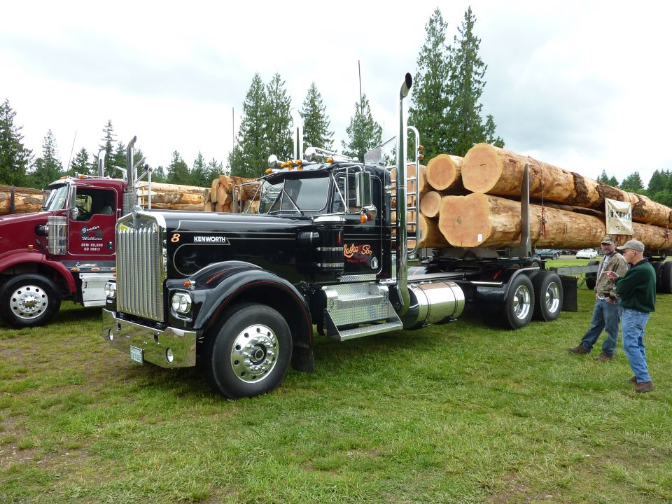 Black 1959 Kenworth W900A logging truck with logs