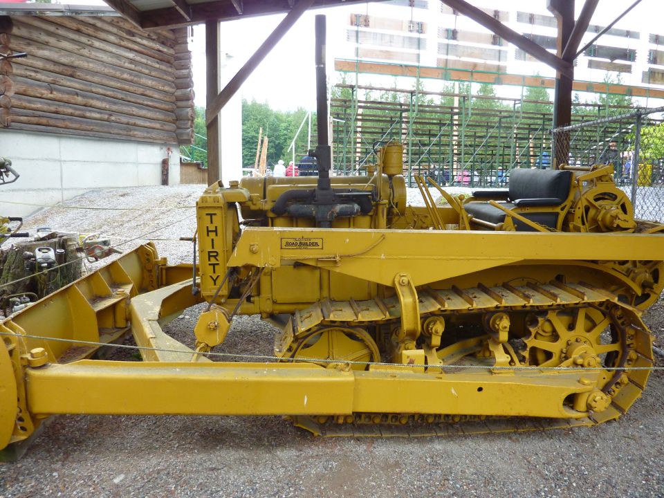 Yellow crawler tractor with a front blade and "THIRTY" written vertically on the side. A "ROAD BUILDER" plate is visible
