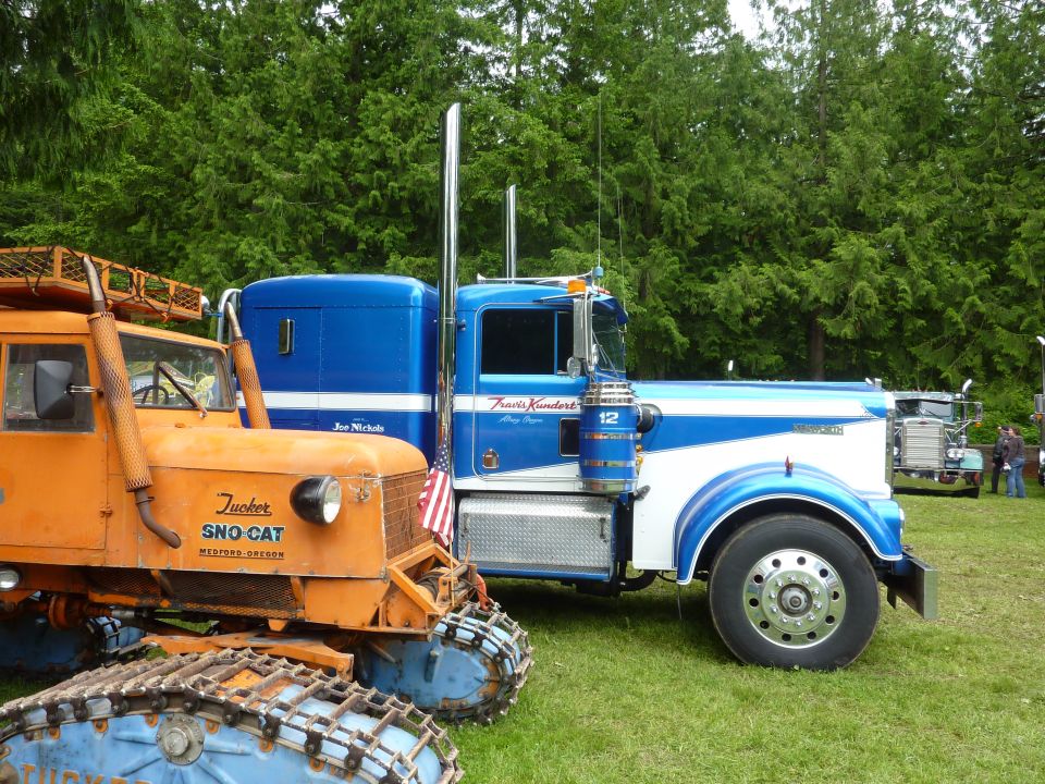Blue and white Kenworth truck side view with "Travis Kundert" text on door
