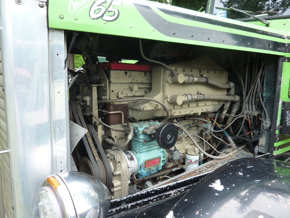 Truck engine bay with green and black paint, chrome fender, and visible engine components
