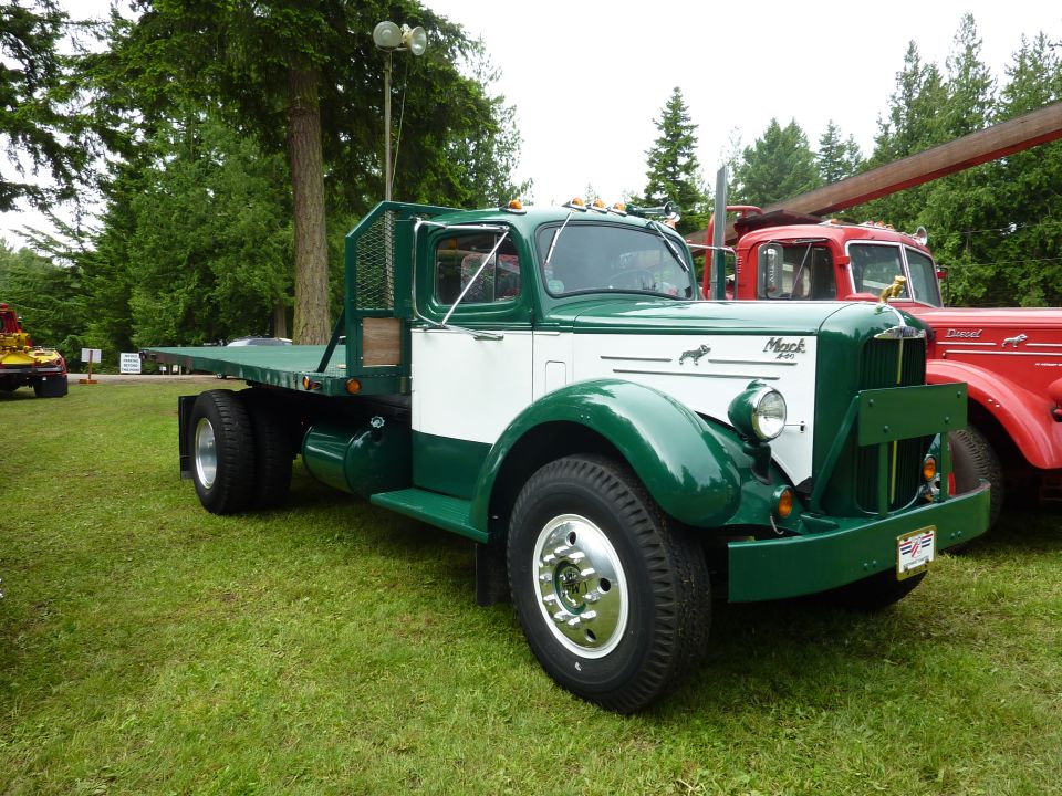 Green and white flatbed truck with a Mack bulldog hood ornament and "Mack" badging