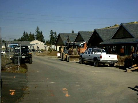 1995 Ford Bronco - A white Chevrolet pickup truck is parked on a street with construction in the background.