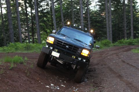 1995 Ford Bronco - This Ford Bronco is navigating a wooded trail with a steep incline.
