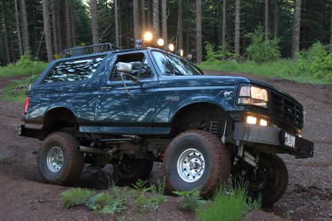 1995 Ford Bronco - This lifted Ford Bronco is shown off-road with aftermarket lights on the roof.