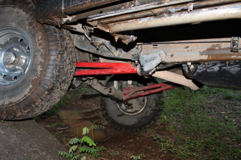 1995 Ford Bronco - The underside of a vehicle shows off-road modifications and mud accumulation.