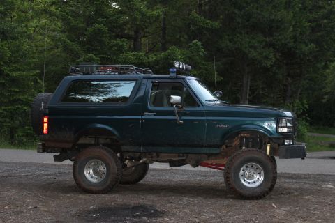 1995 Ford Bronco - This modified Ford Bronco is shown from the side, with a roof rack and off-road tires.