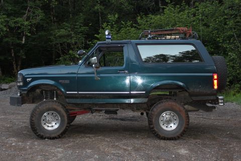 1995 Ford Bronco - This modified Ford Bronco sits off-road with its side facing the camera.