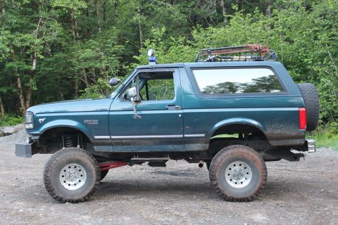 1995 Ford Bronco - This lifted 1995 Ford Bronco features a roof rack and off-road tires, suggesting it's ready for adventure.
