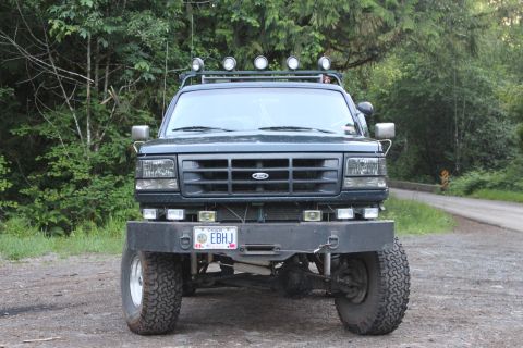 1995 Ford Bronco - This Ford Bronco features a custom bumper and roof-mounted lights, seen from the front.