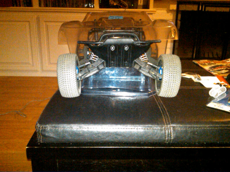 Remote control car chassis with large tires and suspension, viewed from rear