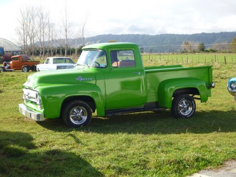1969 Lincoln Continental - This green Ford F-100 pickup truck is parked in a grassy field with other vehicles visible.