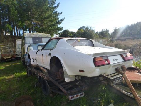 1969 Lincoln Continental - This white 1974 Chevrolet Corvette Stingray coupe is missing its wheels while being transported on a flatbed truck.