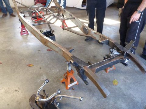 1969 Lincoln Continental - The chassis of a vehicle is disassembled and supported by jack stands in a garage setting.