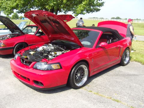 2007 Ford Mustang - A red convertible is parked with its hood open, revealing the engine compartment.