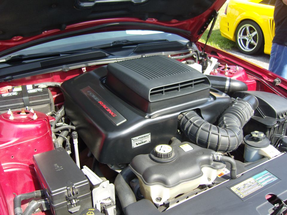 2007 Ford Mustang engine bay with 'Ford Racing' cover and 'Shaker' sticker