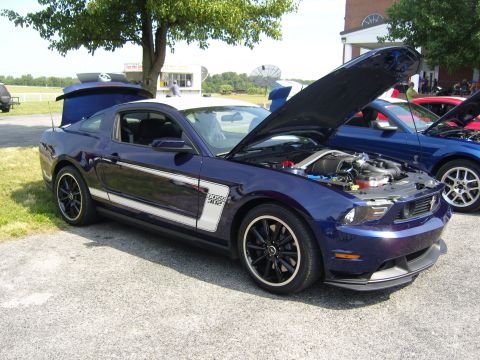 2007 Ford Mustang - A blue Ford Mustang Boss 302 is displayed with its hood open, parked next to other vehicles.