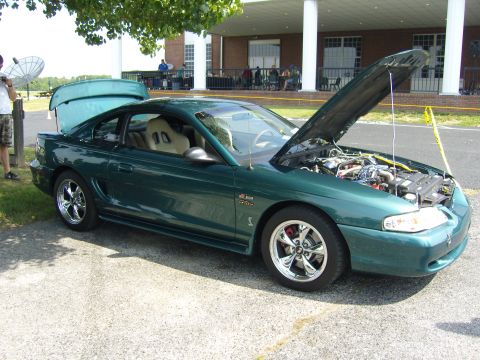 2007 Ford Mustang - A green coupe with its hood and trunk open sits parked outdoors.