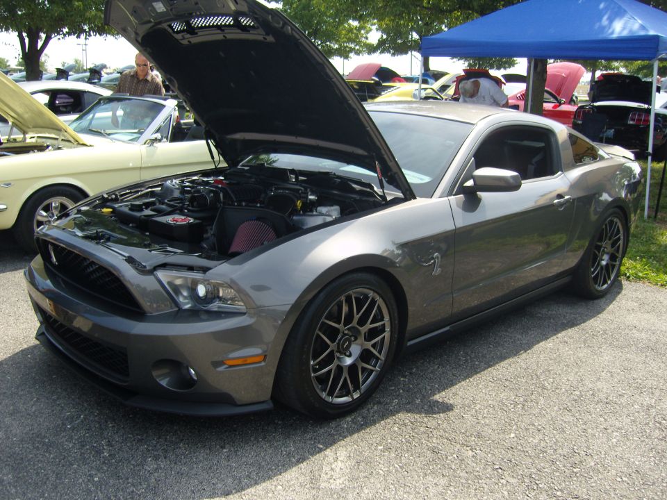 Gray Ford Mustang with hood open, showing engine and aftermarket wheels