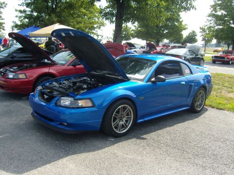2007 Ford Mustang - A blue Ford Mustang GT is displayed with its hood open at an outdoor car show.