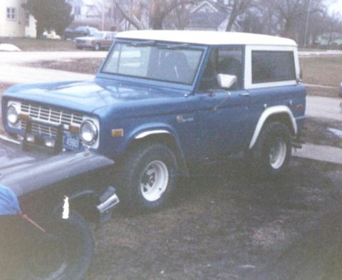 1995 Ford Bronco - This 1978 Ford Bronco is parked outdoors next to another vehicle.