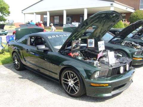 2007 Ford Mustang - A dark green 2007 Ford Mustang is displayed with its hood open, revealing the engine and informational photos.