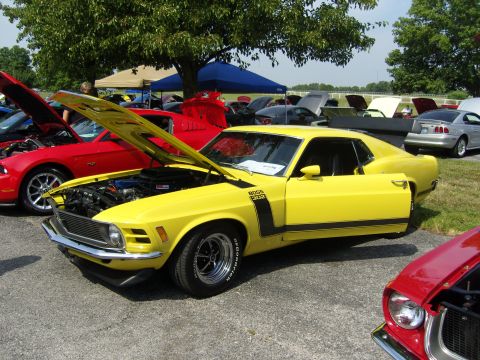 2007 Ford Mustang - Yellow 1970 Ford Mustang Boss 302 at a car show, with other vehicles visible.