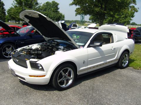 2007 Ford Mustang - A white Ford Mustang is displayed with its hood open, revealing the engine compartment.