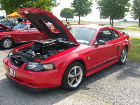 2007 Ford Mustang - A red Ford Mustang is parked outside with its hood up, revealing the engine compartment.