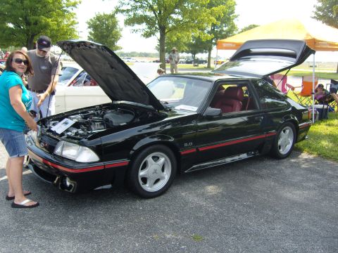 2007 Ford Mustang - Black Ford Mustang with red interior, hood and trunk open, parked outdoors.