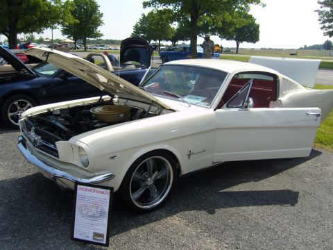 2007 Ford Mustang - A classic white 1965 Ford Mustang 2+2 is displayed with its hood and door open at an outdoor event.