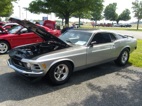 2007 Ford Mustang - A silver 1970 Ford Mustang coupe is parked with its hood open at an outdoor car show.
